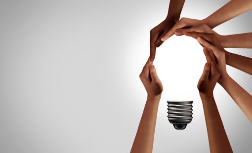 diverse hands forming a lightbulb on a white background
