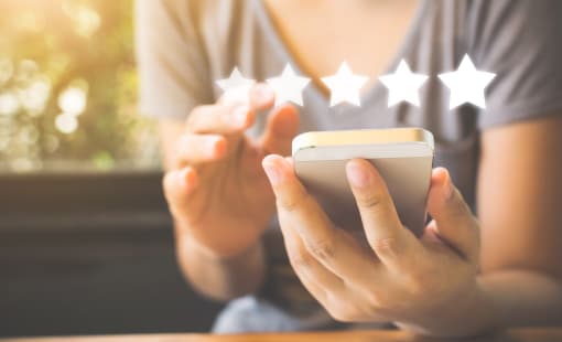 person giving five star review using cell phone