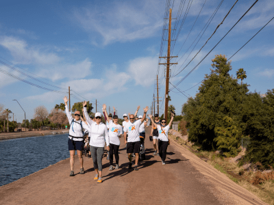 AZCREW members walking along riverwalk with hands in the air for a fundraiser