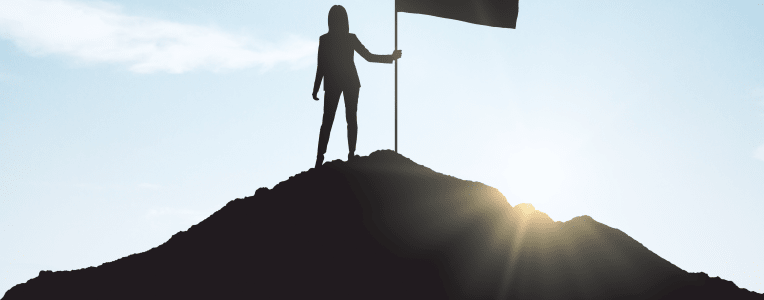 woman with flag silhouette at summit