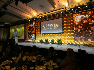 CREW Network event speaker on a well decorated stage