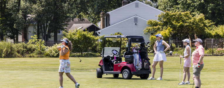 Four golfers with a cart.