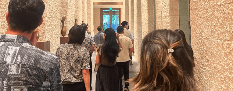 People walking down a museum hallway