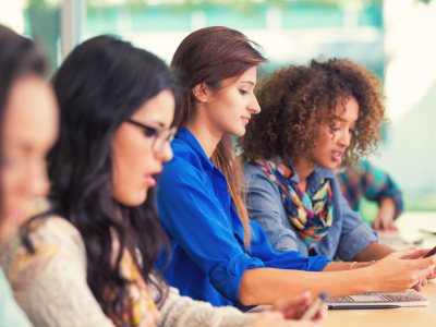 High school or college girls using smart phones in classroom