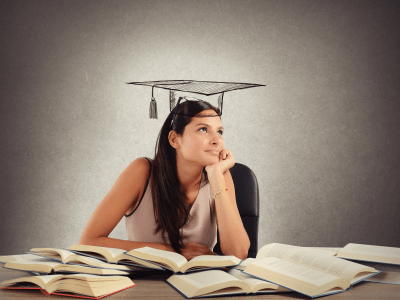 Young student between books dreams the graduation