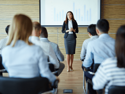 Female teacher or speaker explaining project to managers