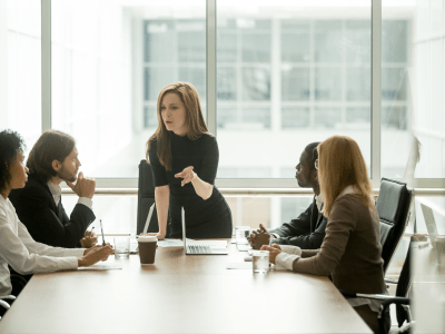 woman leading serious discussion at conference table