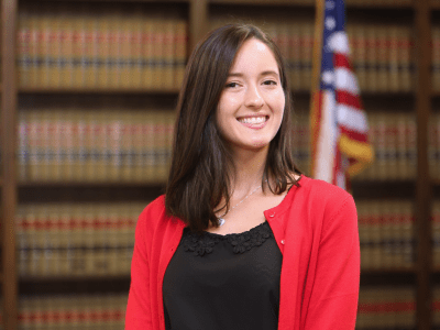 Woman smiling in library in front of American flag