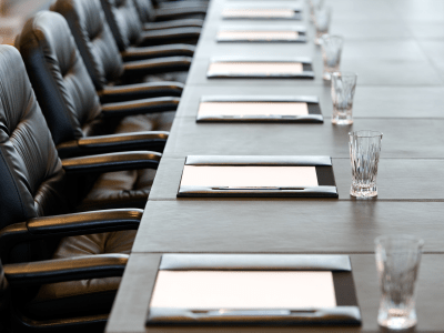 boardroom table with neatly placed papers and water glasses