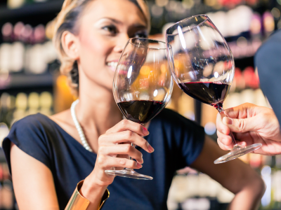 Close up of Asian couple clinking glasses in wine shop