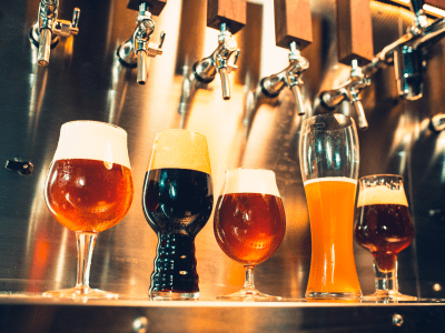 The beer taps in a pub. nobody. Selective focus. Alcohol concept. Vintage style. Beer craft. Bar table. Steel taps. Shiny taps. Glass of beer