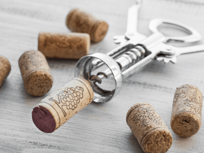 Corkscrew and wine corks on wooden background