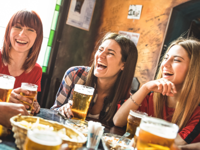 Happy girlfriends women group drinking beer at brewery bar restaurant - Friendship concept with young female friends enjoying time and having genuine fun at cool vintage pub - Focus on left girl