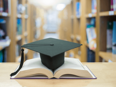 graduation cap over open Books on Library room,Education concept