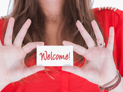 Woman in red showing a business card, welcome