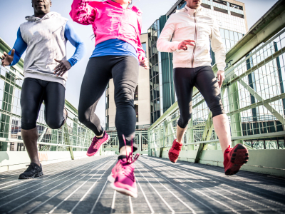 Three runners sprinting outdoors - Sportive people training in a urban area - healthy lifestyle and sport concepts