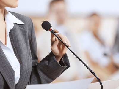 business woman speaking into a microphone