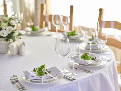 beautifully decorated festive table with plates and glasses and a bouquet of flowers in a restaurant