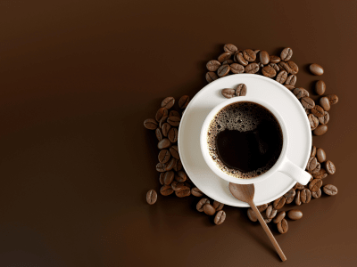 white coffee cup on brown background with coffee beans