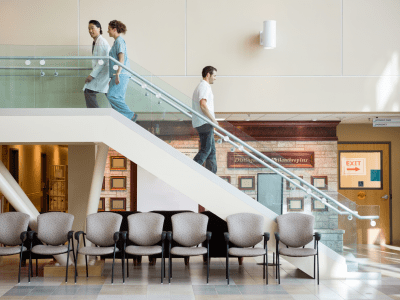Side view of medical team and man using staircase in hospital