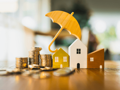 house model and pile of money with an umbrella