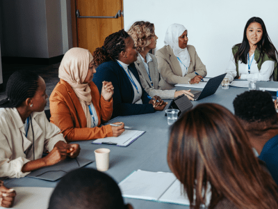 A multiethnic team engaged in a collaborative meeting workshop, focusing on discussion and teamwork. Diverse professionals working together around a conference table.