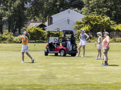 Four golfers with a cart.