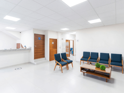 modern medical office with blue chairs and wooden coffee table with marble reception counter