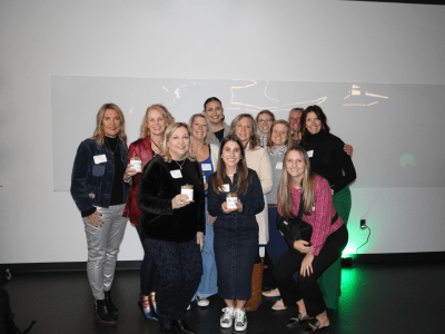 group of ladies standing against a white wall