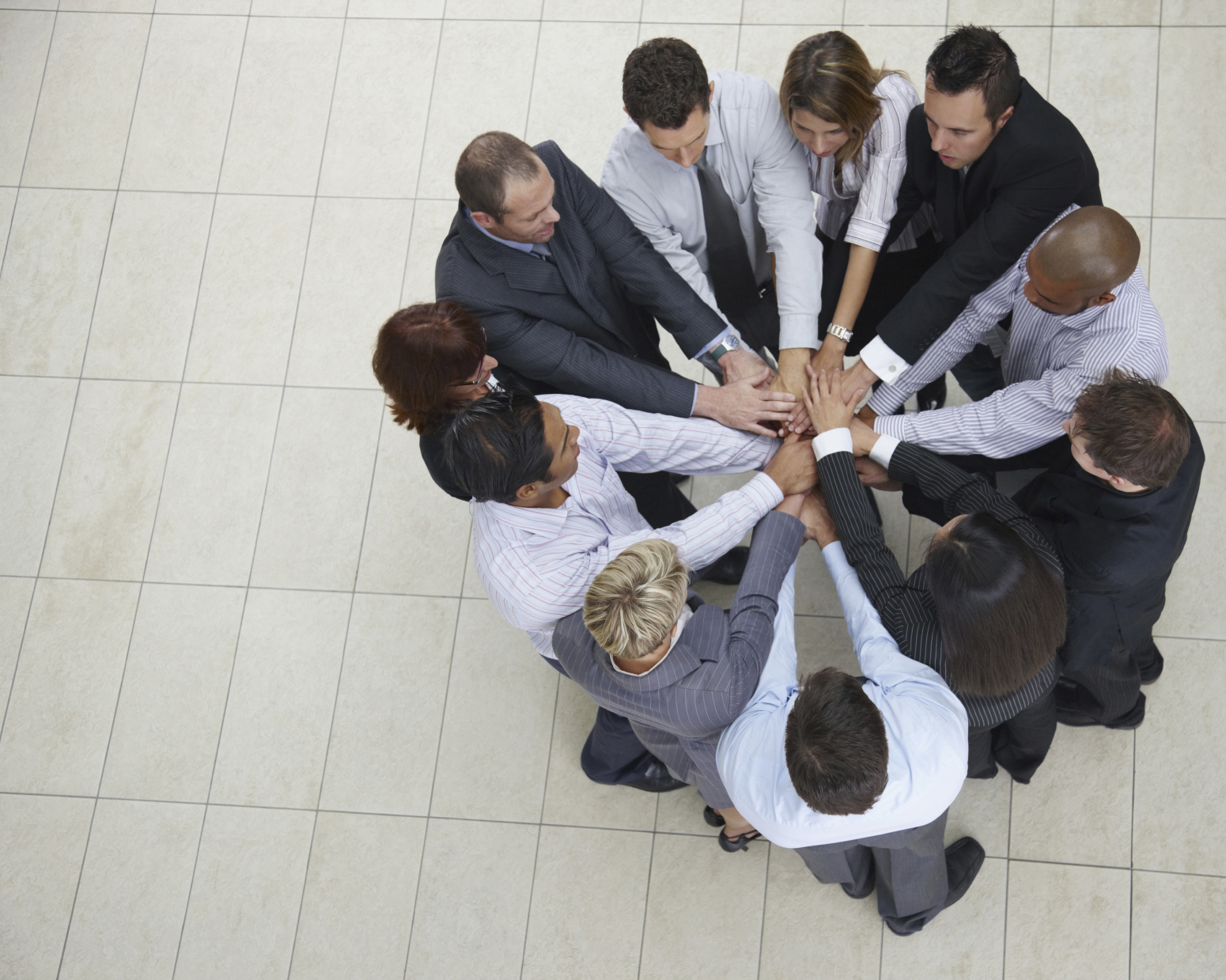 Top view of successful businesspeople putting their hands together