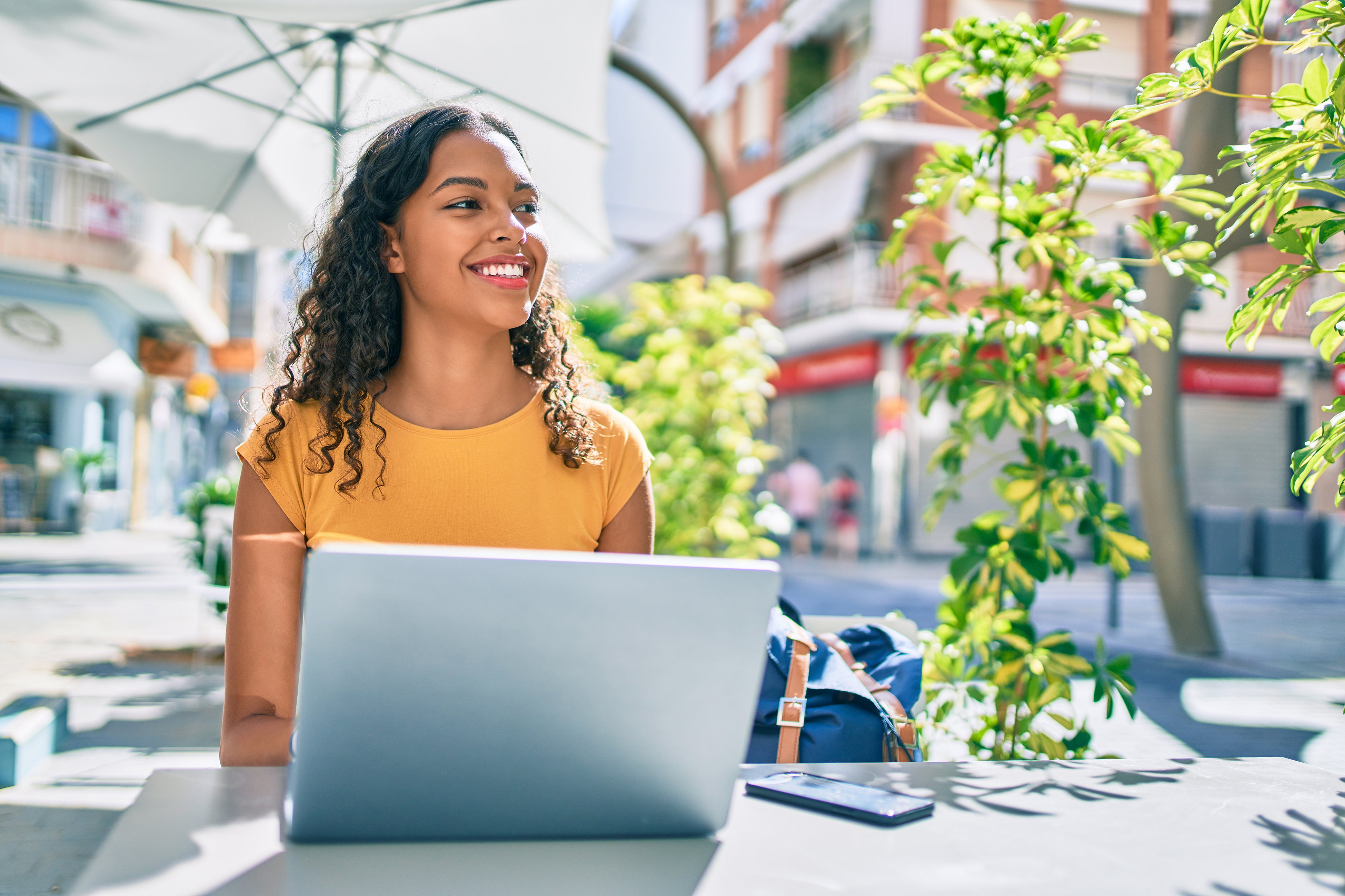 Young african american student girl using laptop sitting on the table at terrace.; Shutterstock ID 1928460668; purchase_order: -; job: -; client: -; other: -