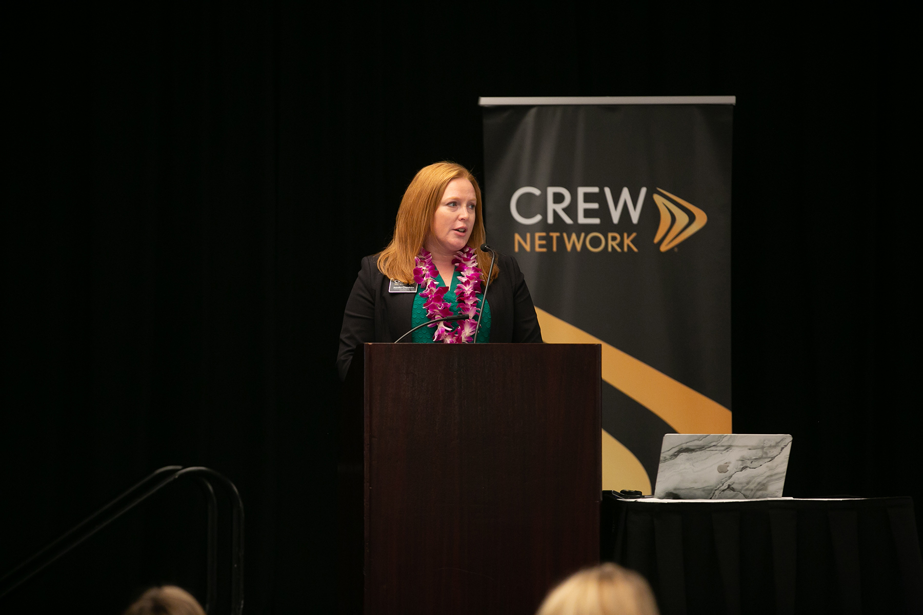 speaker at podium in front of CREW Network sign