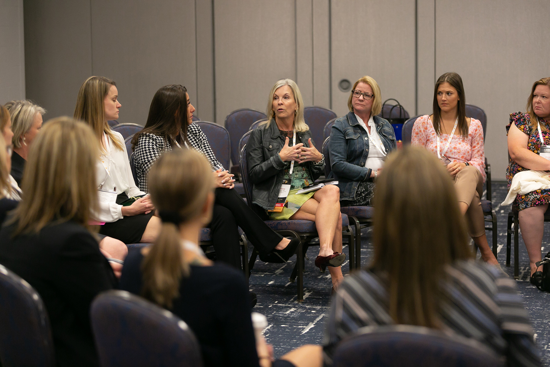 Woman speaking in a group that is seated in a circle at a CREW Network Convention