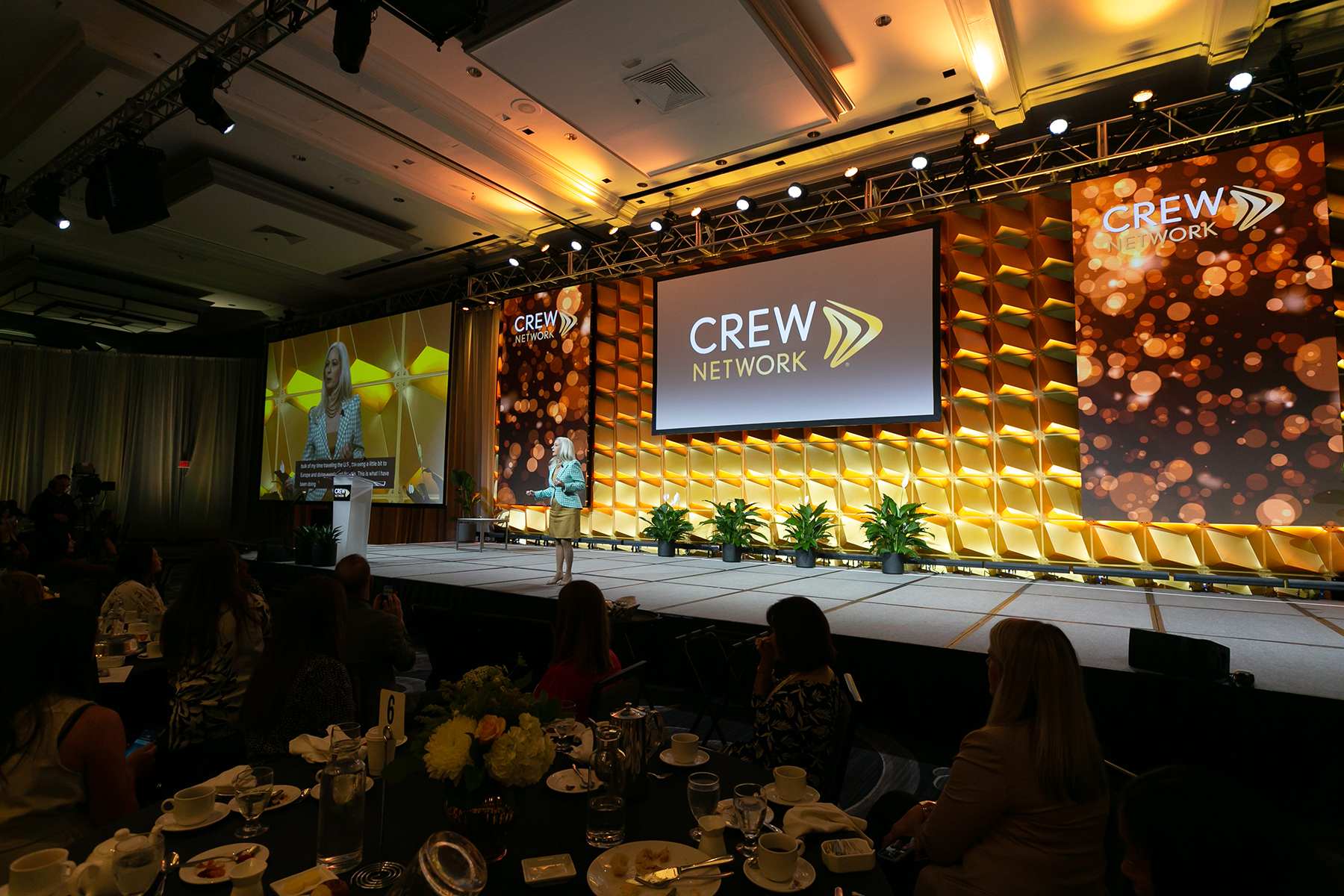 convention stage with speaker and screen that says CREW NETWORK