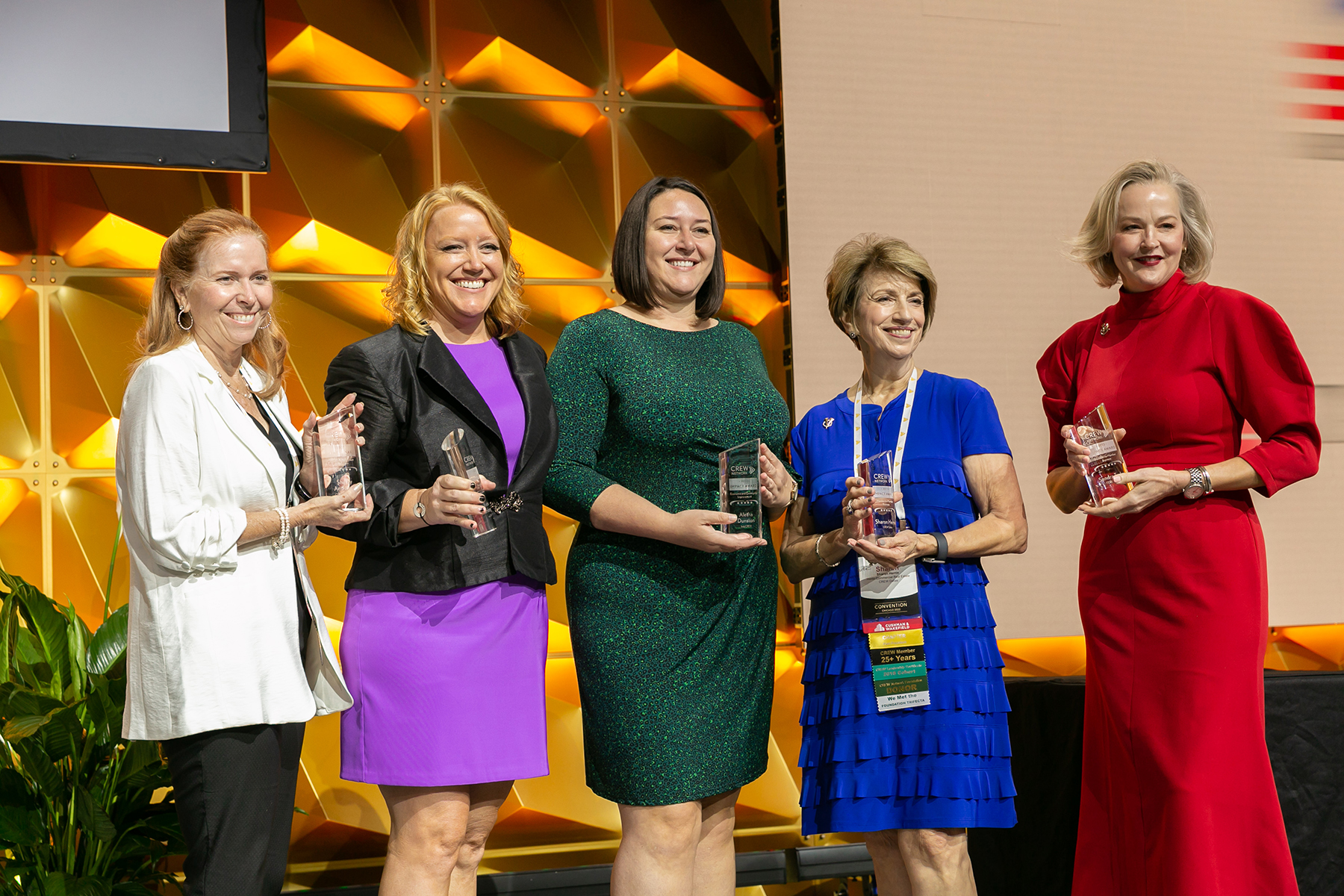 Five women holding CREW Impact awards