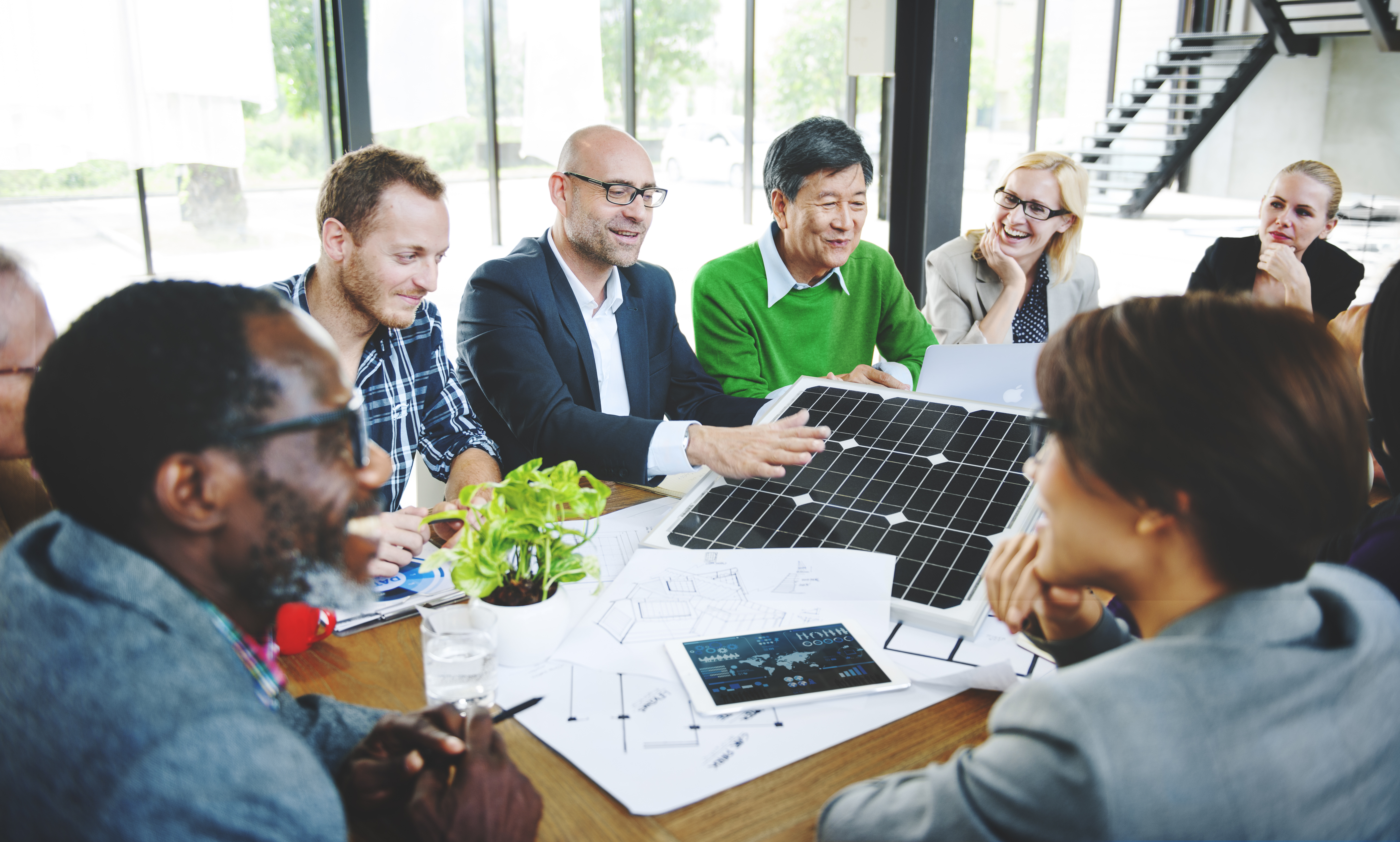 Business People Discuss Solar Power Energy with solar panel on table