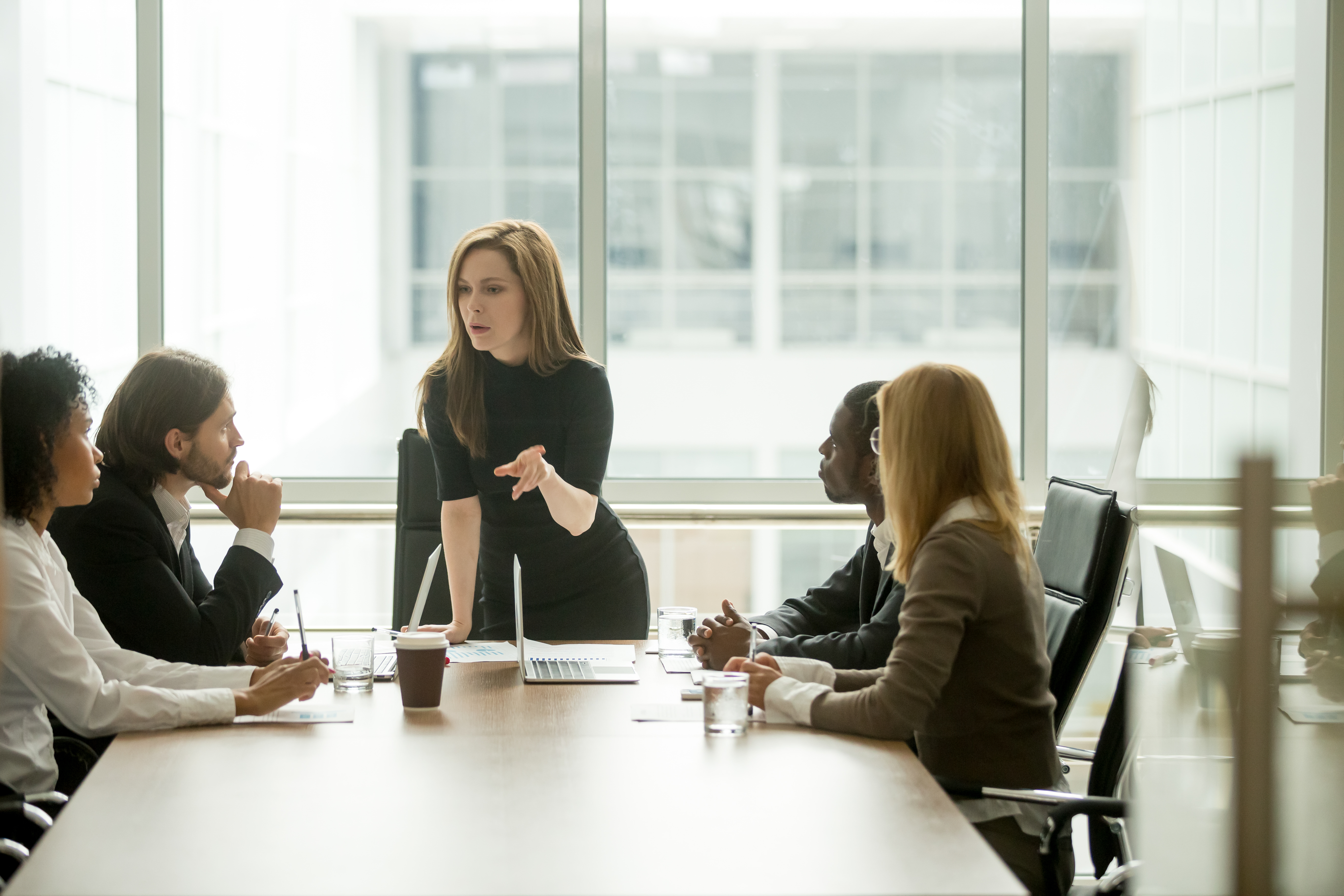 woman leading serious discussion at conference table