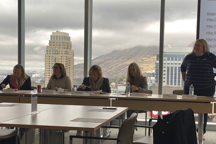 Five women behind a desk at a negotiation