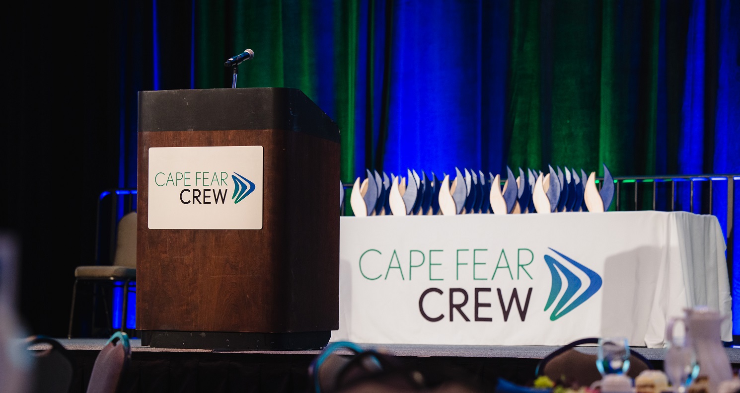 podium and table with awards and cape fear logo on table